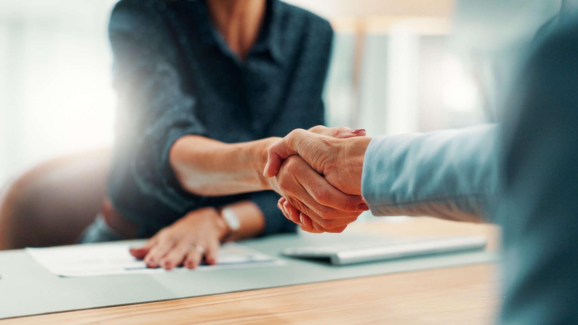 Handschlag, Geschäftsabschluss und Geschäftsleute in einem Büro bei der Unterzeichnung einer Vereinbarung, eines Vertrags oder einer Finanzpartnerschaft. Besprechung, Begrüßung und Finanzberater, der einem Investor bei Investitionsverhandlungen in der Agentur die Hand schüttelt.